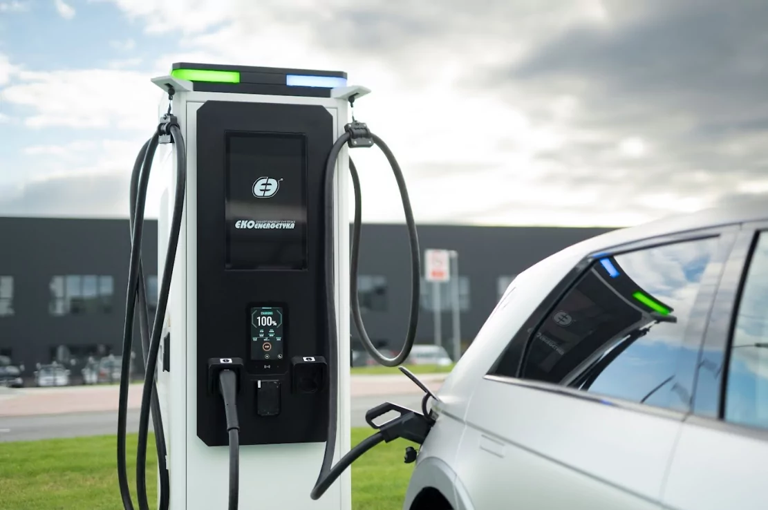 Electric car charging at a station under a clear sky
