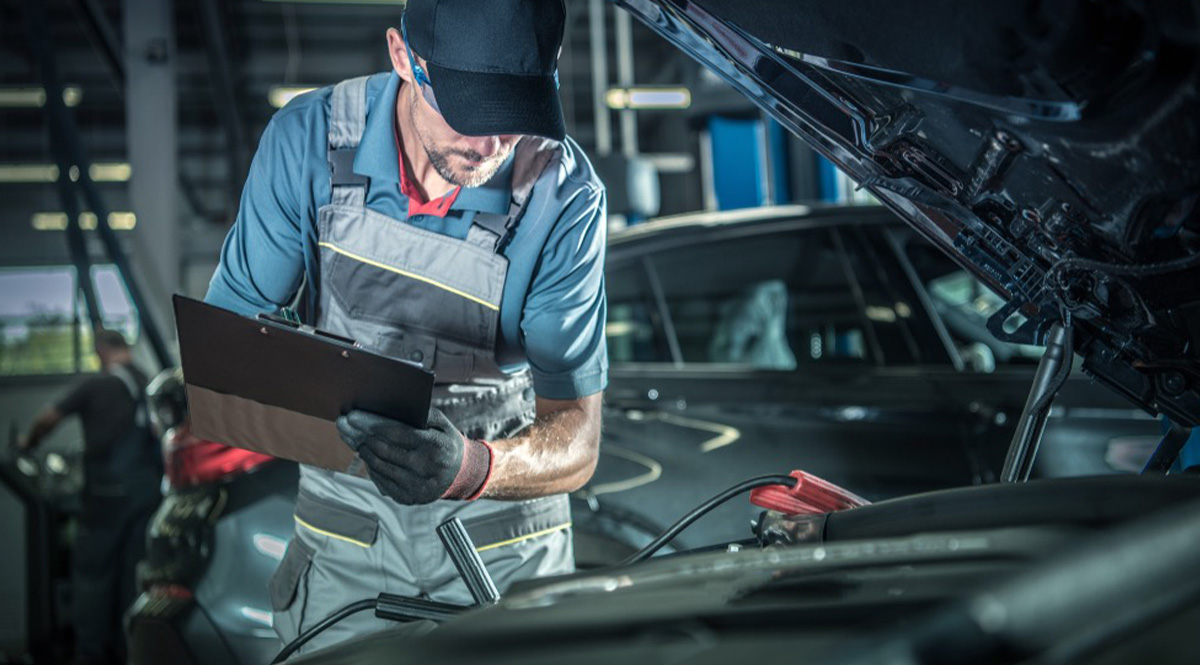 Automotive technician using a digital diagnostic tool on modern vehicles