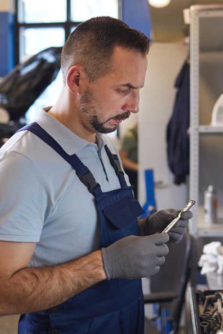 Automotive technician selecting professional repair tools in a workshop