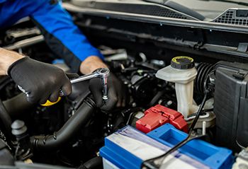 Automotive technician inspecting engine components during routine service