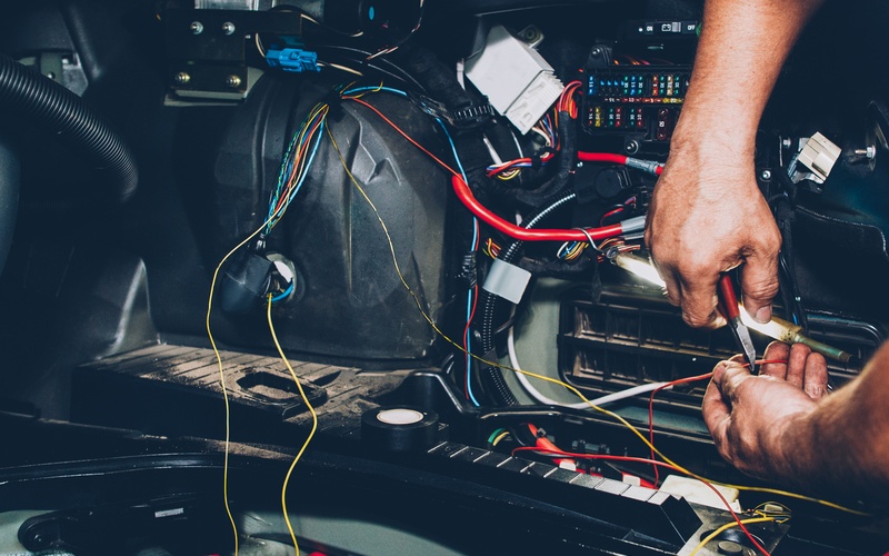 Automotive electrical work showing wiring and connectors under inspection